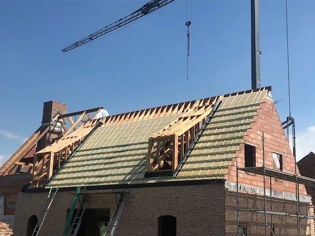Dakconstructie in opbouw op een bakstenen woning